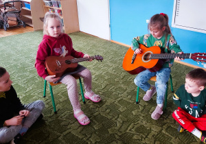Dzieci grają na gitarze i ukulele