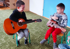Dzieci grają na gitarze i ukulele