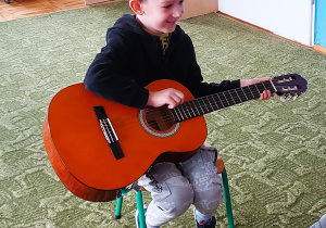 Dzieci grają na gitarze i ukulele