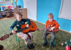 Dzieci grają na gitarze i ukulele