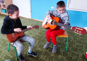 Dzieci grają na gitarze i ukulele