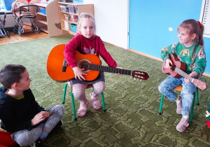 Dzieci grają na gitarze i ukulele
