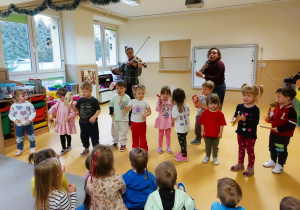 Dzieci grają na instrumentach perkusyjnych przy akompaniamencie altówki