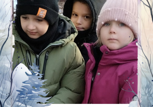 Dzieci wsypują ziarna do karmnika dla ptaków