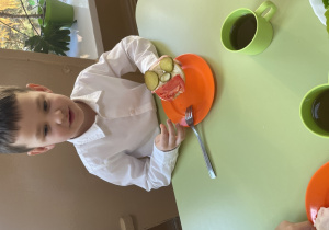 Chłopiec pokazuje wykonaną bułeczkę.