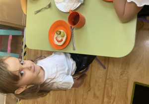 Dziewczynka pokazuje bułeczkę.