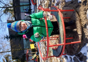 Chłopiec eksperymentuje z lodem, uderzając o metalową rurkę