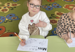 Dziecko miga literę M.