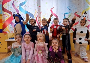 Dzieci pozują do zdjęcia grupowego na balu karnawałowym