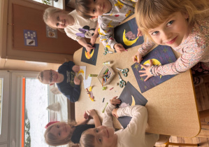 Dzieci wykonują pracę plastyczną z kotem