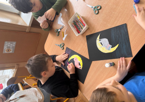 Dzieci wykonują pracę plastyczną z kotem