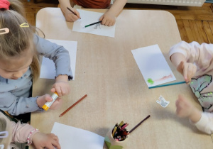 Dzieci wykonują pracę plastyczną z kotem