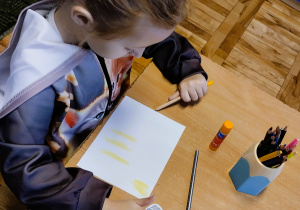 Dzieci wykonują pracę plastyczną z kotem