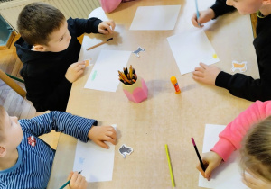 Dzieci wykonują pracę plastyczną z kotem