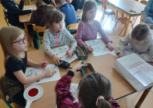 Dzieci kolorują kolorowanki.