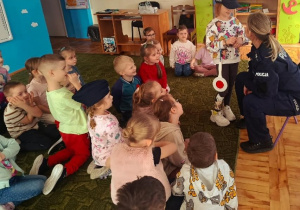 Dzieci słuchają prelekcji funkcjonariuszki policji