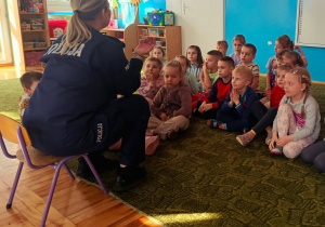Dzieci słuchają prelekcji funkcjonariuszki policji