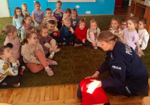Dzieci słuchają prelekcji funkcjonariuszki policji