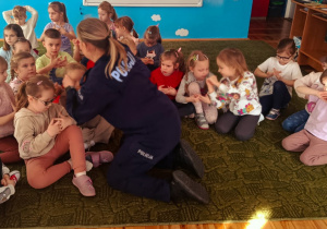 Dzieci słuchają prelekcji funkcjonariuszki policji