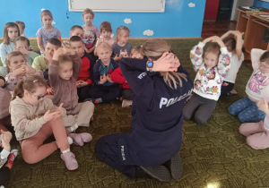 Dzieci ćwiczą pozycję bezpieczną związaną z atakiem psa