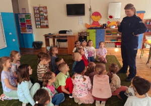 Dzieci słuchają prelekcji funkcjonariuszki policji