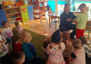 Dzieci słuchają prelekcji funkcjonariuszki policji