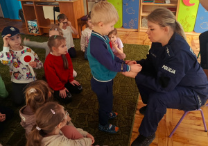 Dzieci słuchają prelekcji funkcjonariuszki policji