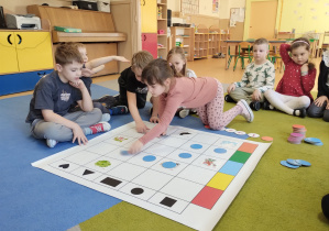 Dziewczynka układa scieżkę na planszy