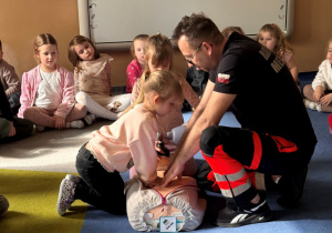 Dzieci ćwiczą na fantomie udzielanie pierwszej pomocy