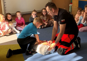Dzieci ćwiczą na fantomie udzielanie pierwszej pomocy