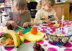 Dzieci kroją owoce do sałatki owocowej