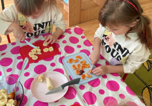 Dzieci kroją owoce do sałatki owocowej