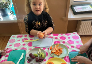 Dziewczynka obiera mandarynkę