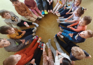 Dzieci pokazują kolorowe skarpetki na swoich stopach