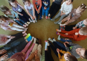 Dzieci pokazują kolorowe skarpetki na swoich stopach