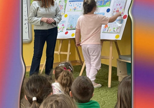 Dziewczynka pokazuje wykonaną pracę konkursową