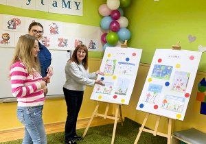 Komisja konkursowa pokazuje prace plastyczne dzieci