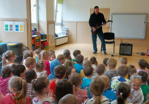 Dzieci słuchają brzmienia gitary elektrycznej