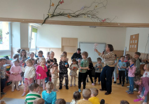 Dzieci grają na instrumentach perkusyjnych akompaniując gitarze