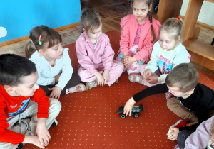 Chłopiec bawi się skręconym wspólnie z grupą samochodem