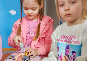 Dziewczynka skręca elementy plastikowego samochodu