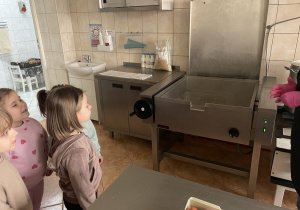 Dzieci zwiedzają kuchnię przedszkolna.