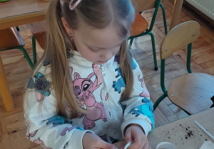 Dziewczynka ozdabia naklejkami pojemnik na owies