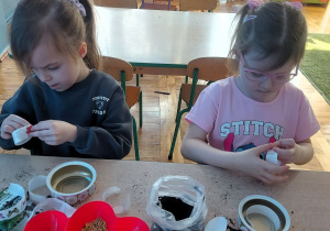 Dziewczynki ozdabiają naklejkami pojemniki na owies