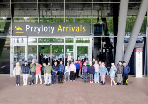 Dzieci pozują do zdjęcia przed lotniskiem