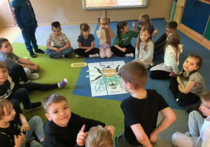 Dzieci siedzą w kole rozmawiają o pszczołach