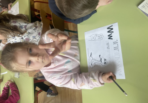 Dziewczynka miga literę w.