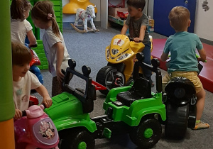 Dzieci bawią się w różnorodnych strefach ruchu w sali zabaw