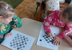 Dzieci kolorują według wskazówek szachownicę