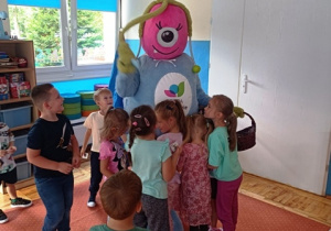 Dzieci witają się z maskotką witającą ich w przedszkolu w nowym roku szkolnym